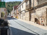 a motorcycle parked next to some old buildings on a cobblestone street in a town