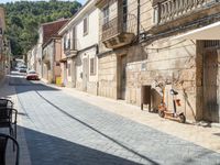 a motorcycle parked next to some old buildings on a cobblestone street in a town