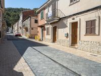 a motorcycle parked next to some old buildings on a cobblestone street in a town