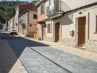 a motorcycle parked next to some old buildings on a cobblestone street in a town