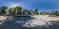 an 360 - shot view of homes in the suburbs near trees and bushes of town