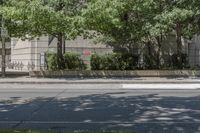 the sidewalk has a parking meter on it that has graffiti painted over the street and trees near the building