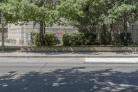 the sidewalk has a parking meter on it that has graffiti painted over the street and trees near the building