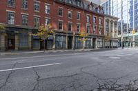 a city street with parked cars and pedestrians walking past stores and buildings on either side of the street