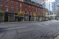 a city street with parked cars and pedestrians walking past stores and buildings on either side of the street