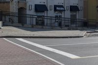 a car stopped at an intersection on a city street, on a clear day with no people