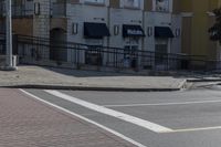 a car stopped at an intersection on a city street, on a clear day with no people