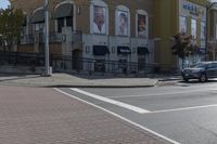 a car stopped at an intersection on a city street, on a clear day with no people