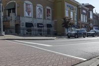 a car stopped at an intersection on a city street, on a clear day with no people