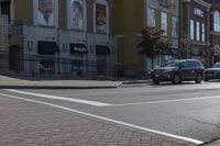 a car stopped at an intersection on a city street, on a clear day with no people