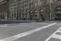 a crosswalk on the road near some building's windows and one with traffic lights