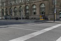 a crosswalk on the road near some building's windows and one with traffic lights