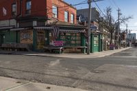 a empty city street with a small restaurant in the background on the corner of the intersection