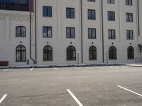 an empty parking lot with a red stop sign outside of an office building in the city