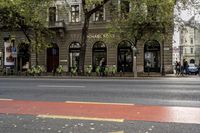 a bicycle sitting next to a street with people eating out of tables on it and parked in front