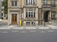 an empty building with signs on the street and people on bikes in traffic passing by