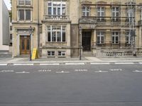 an empty building with signs on the street and people on bikes in traffic passing by