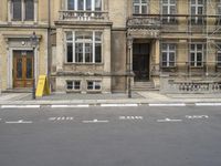 an empty building with signs on the street and people on bikes in traffic passing by