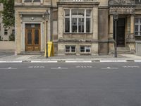 an empty building with signs on the street and people on bikes in traffic passing by