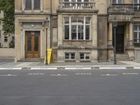 an empty building with signs on the street and people on bikes in traffic passing by