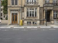 an empty building with signs on the street and people on bikes in traffic passing by