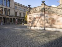 the brick square is in a courtyard with stone columns and lamp posts with pillars on each side