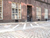 an empty street and parking spots, on the side of a building, near a doorway