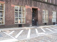 an empty street and parking spots, on the side of a building, near a doorway