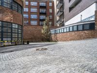 a stone paved courtyard area with an empty parking space and a building in the background