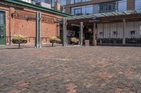 a view of a building with brick pavers and a patio area with seating on top