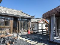 a small patio area with tables and a grill on it outside of a house in china