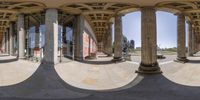 a fish eye view shows the architecture with pillars and columns of a building behind it