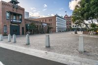 the town hall sits empty and on its side on a street corner surrounded by brick buildings