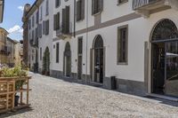 empty courtyard with flower boxes, chairs and umbrellas in front of a white building