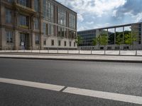 the large building is next to the road and two buildings are behind it and one is on a bicycle