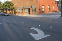 the intersection of a street with the building in the background with one arrow pointing upwards