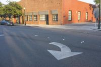 the intersection of a street with the building in the background with one arrow pointing upwards