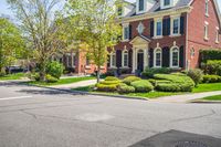 a large red brick house and yard surrounded by bushes and bushes around it's edges