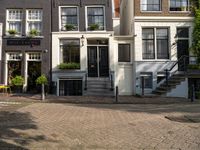 the courtyard is made out of brick and features lots of windows, a tree, a yellow chair and a street sign