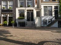 the courtyard is made out of brick and features lots of windows, a tree, a yellow chair and a street sign