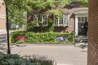 a very nice house in a quiet neighborhood in front of the street signs and plants