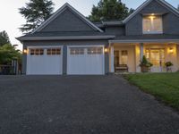 a large two story house with a long driveway in front and white garage doors on one side