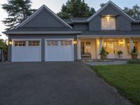 a large two story house with a long driveway in front and white garage doors on one side