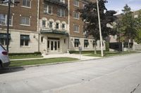 an older, two story building has an entrance to the front and windows and plants
