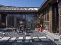 a room that has a small courtyard area with two tables and chairs in it near a fence