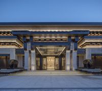 the entrance and atrium are separated by glass, stone and steel pillars and pillars at night