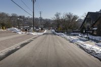 street view with cars parked on the left side of the road and power lines overhead