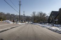 street view with cars parked on the left side of the road and power lines overhead