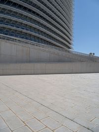 a black fire hydrant is sitting in the concrete area in front of a large building