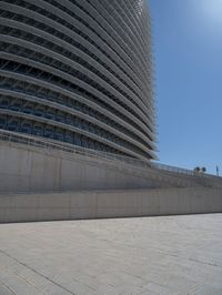 a black fire hydrant is sitting in the concrete area in front of a large building